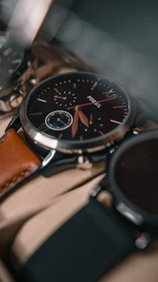 A close-up of a stylish watch resting on a leather bag, highlighting fine craftsmanship and elegant details.