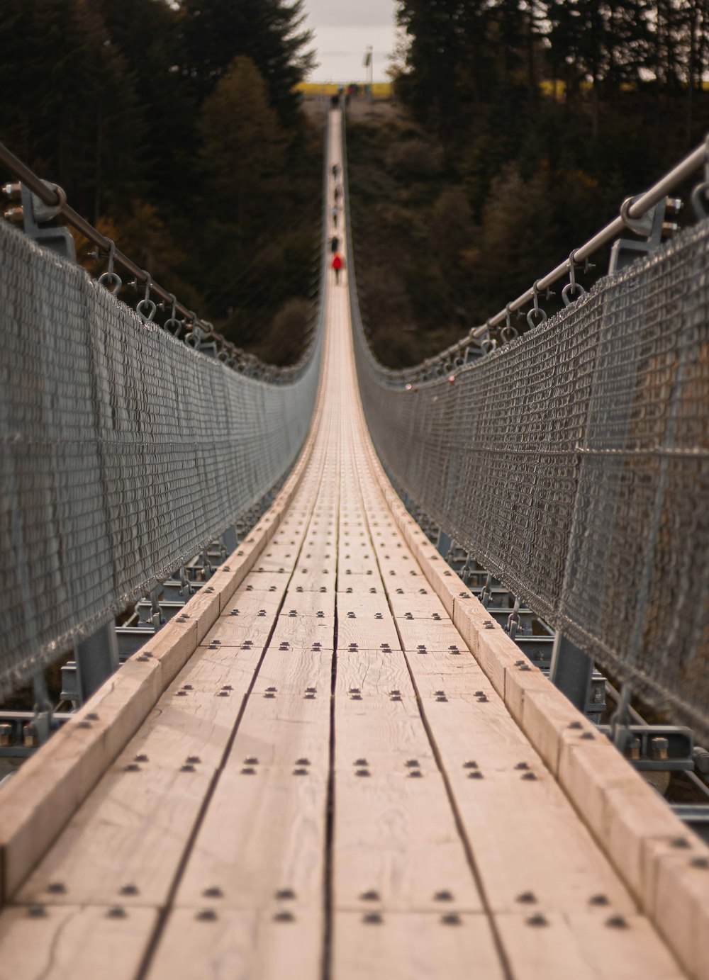 a long suspension bridge with a red stop sign on top of it