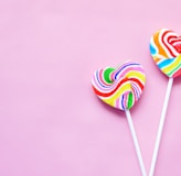 a couple of lollipops sitting on top of a pink surface