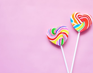 a couple of lollipops sitting on top of a pink surface