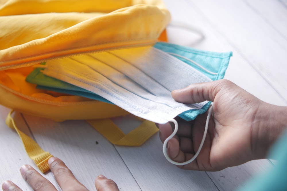 a person is putting a face mask on a bag