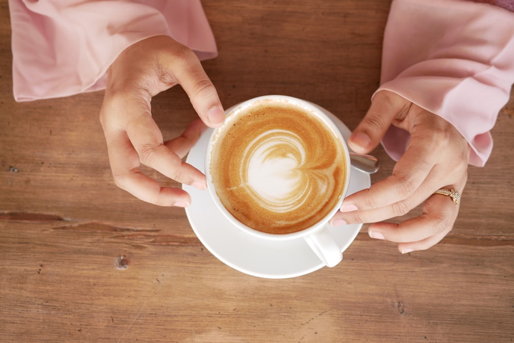 a person holding a cup of coffee in their hands