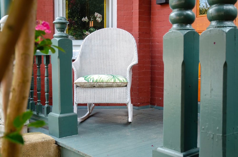 a white rocking chair sitting on a porch