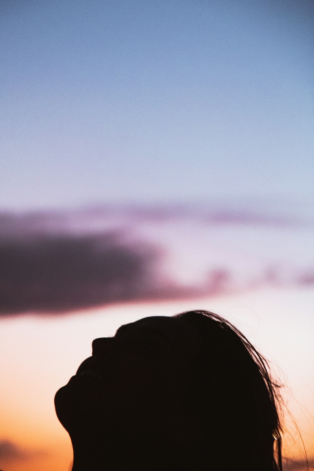 a silhouette of a person with a cell phone in their hand