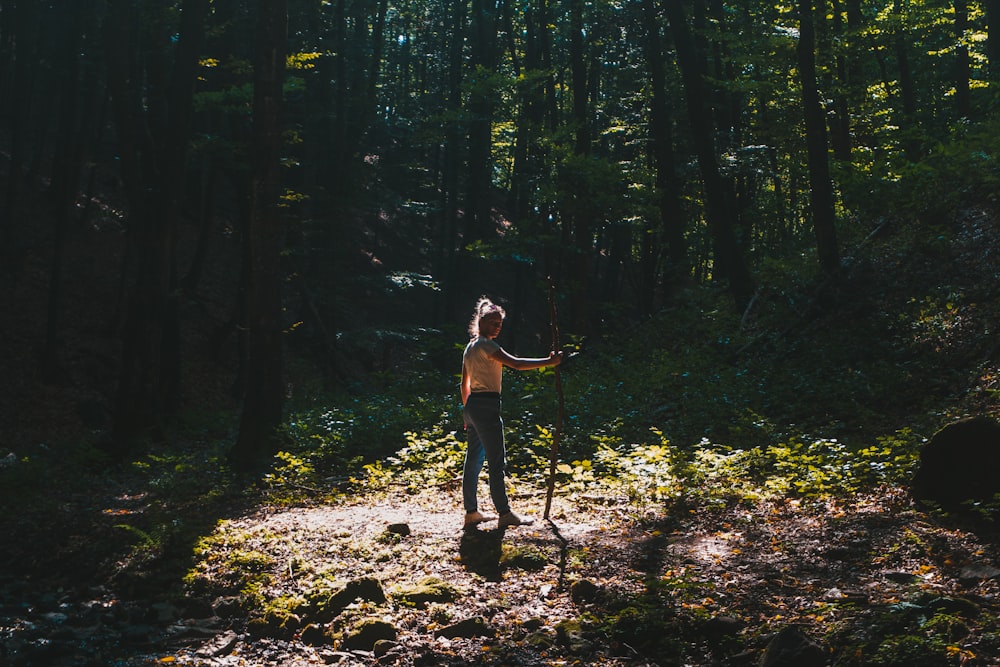 a woman standing in the middle of a forest