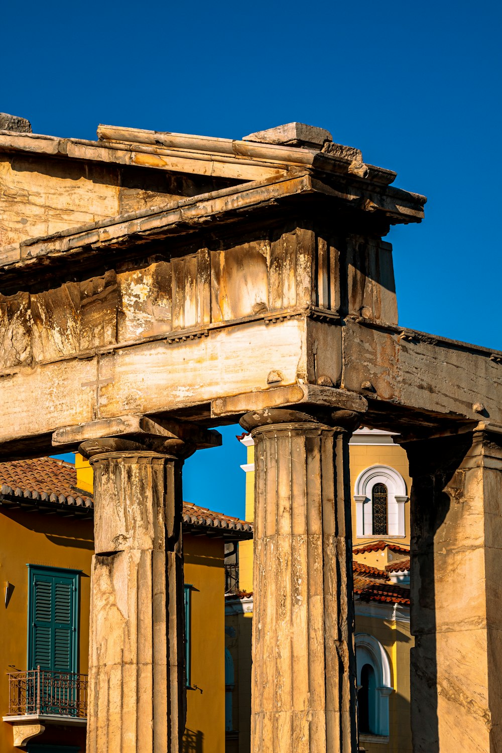 Un edificio antiguo con columnas y una torre del reloj al fondo