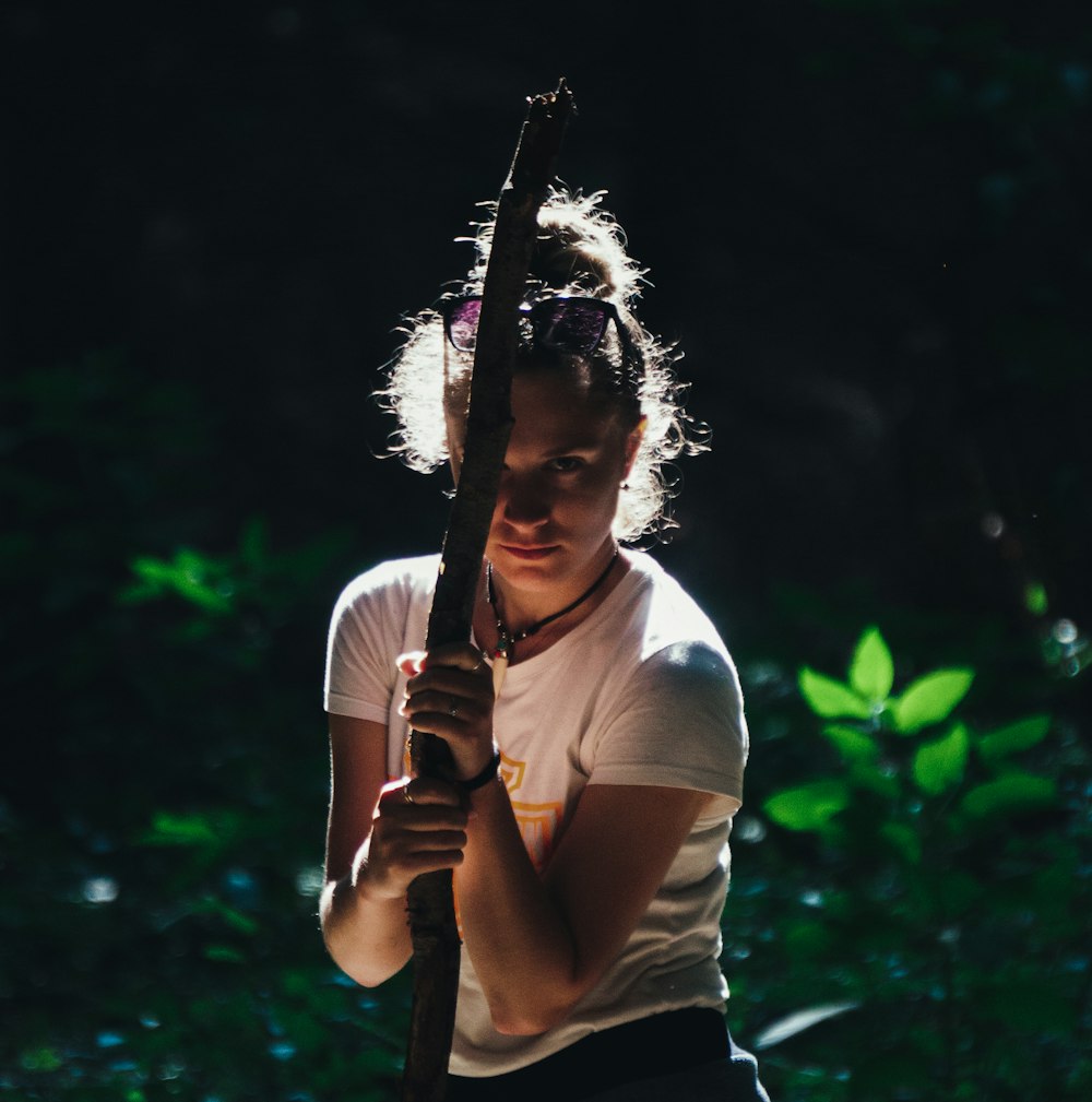 a woman holding a wooden stick in her hands