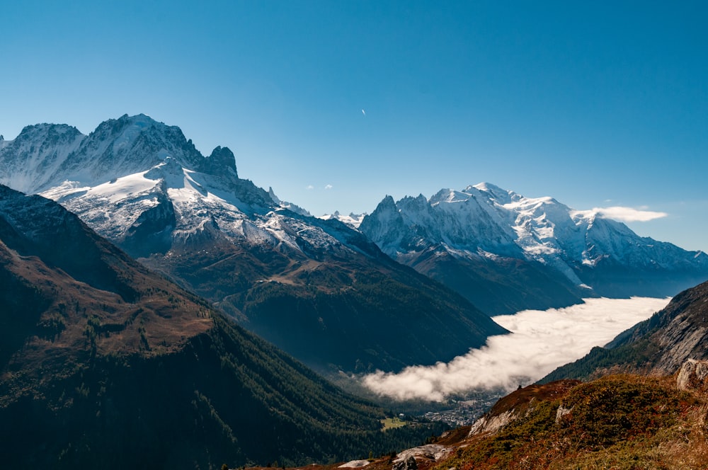 a view of a mountain range with clouds in the foreground