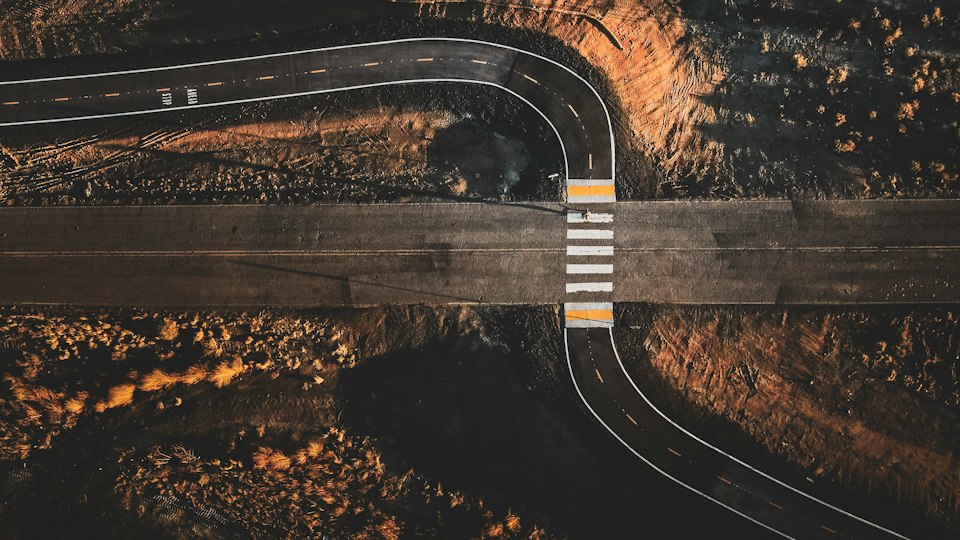 An aerial view of a winding desert highway stretching across the Arizona landscape