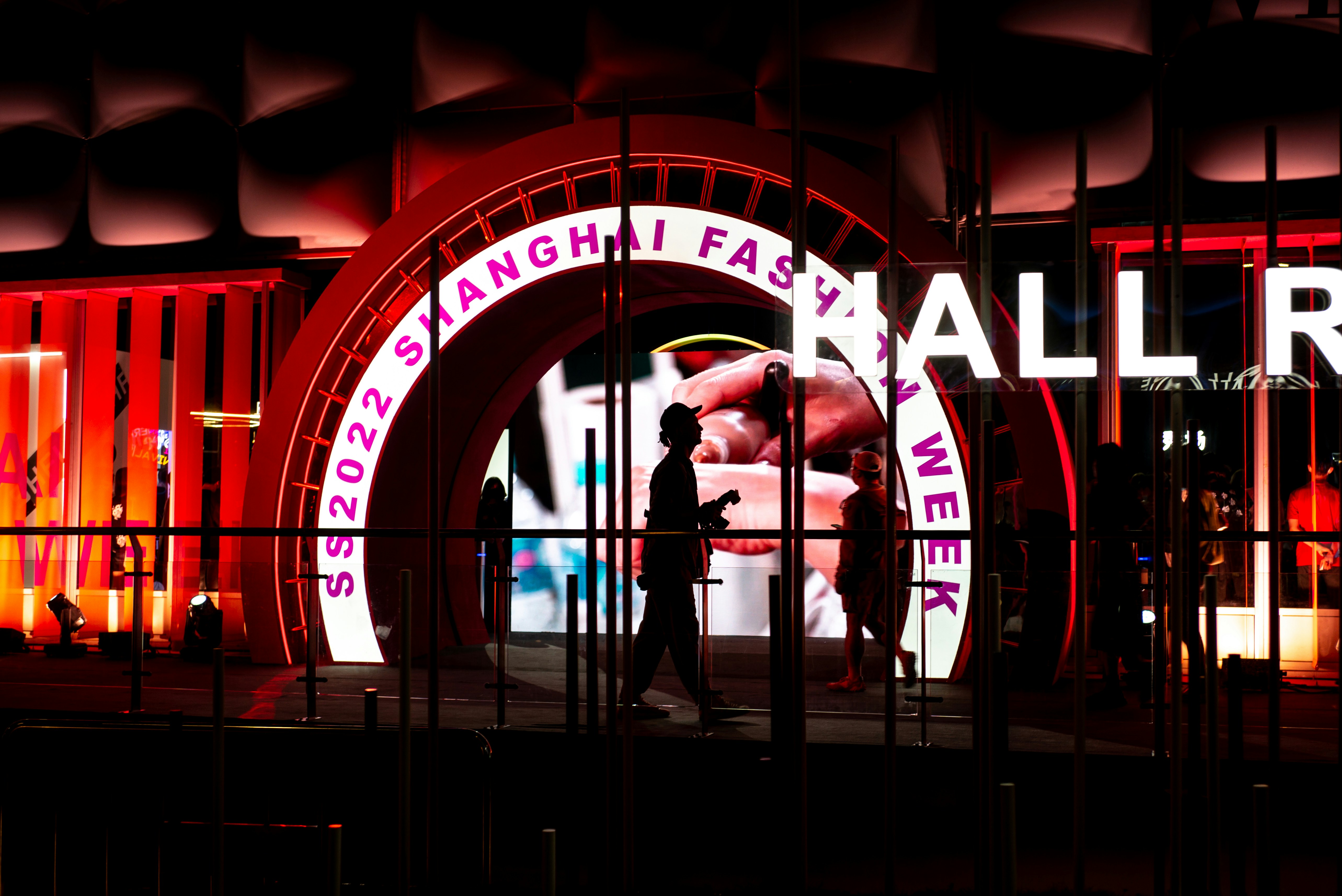 a man is standing in front of a neon sign