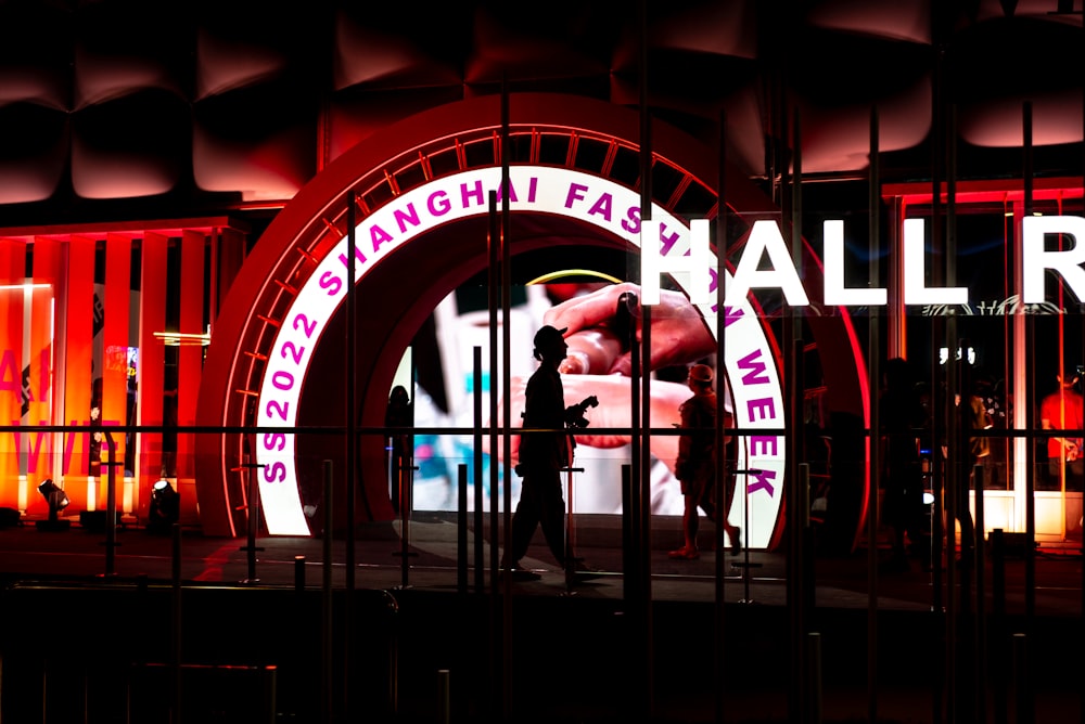 a man is standing in front of a neon sign