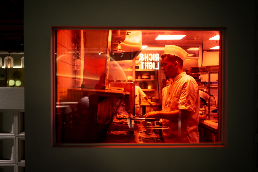 a man working in a kitchen with a red light