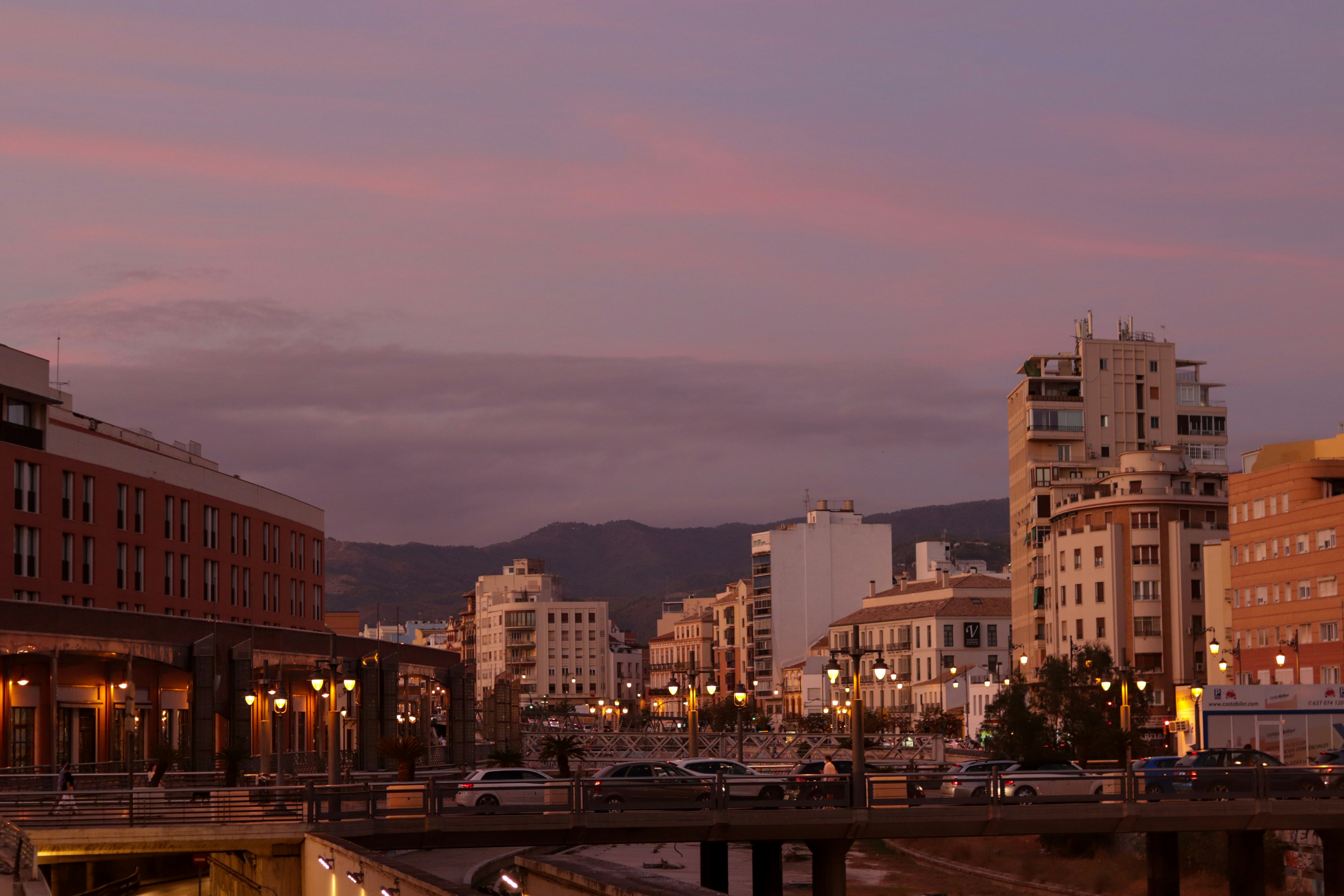 a view of a city from a bridge at dusk