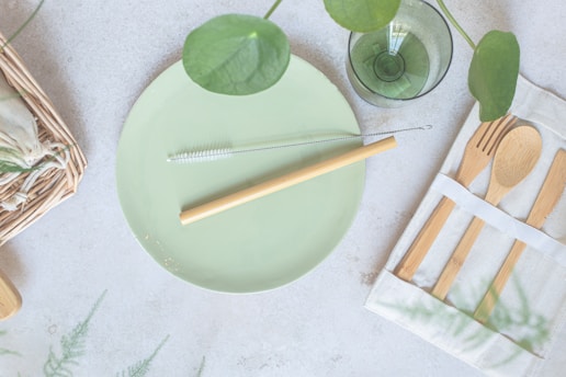 a green plate with a fork, knife, and napkin on it