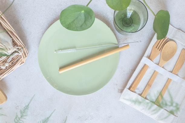 a green plate with a fork, knife, and napkin on it