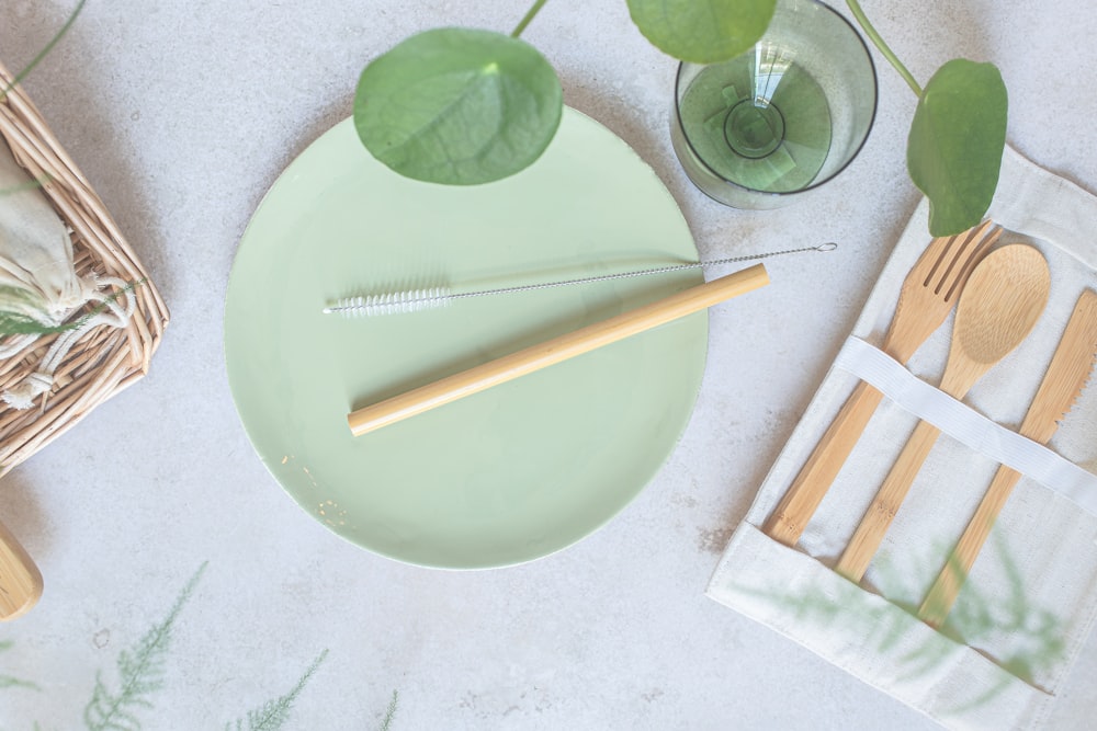 a green plate with a fork, knife, and napkin on it