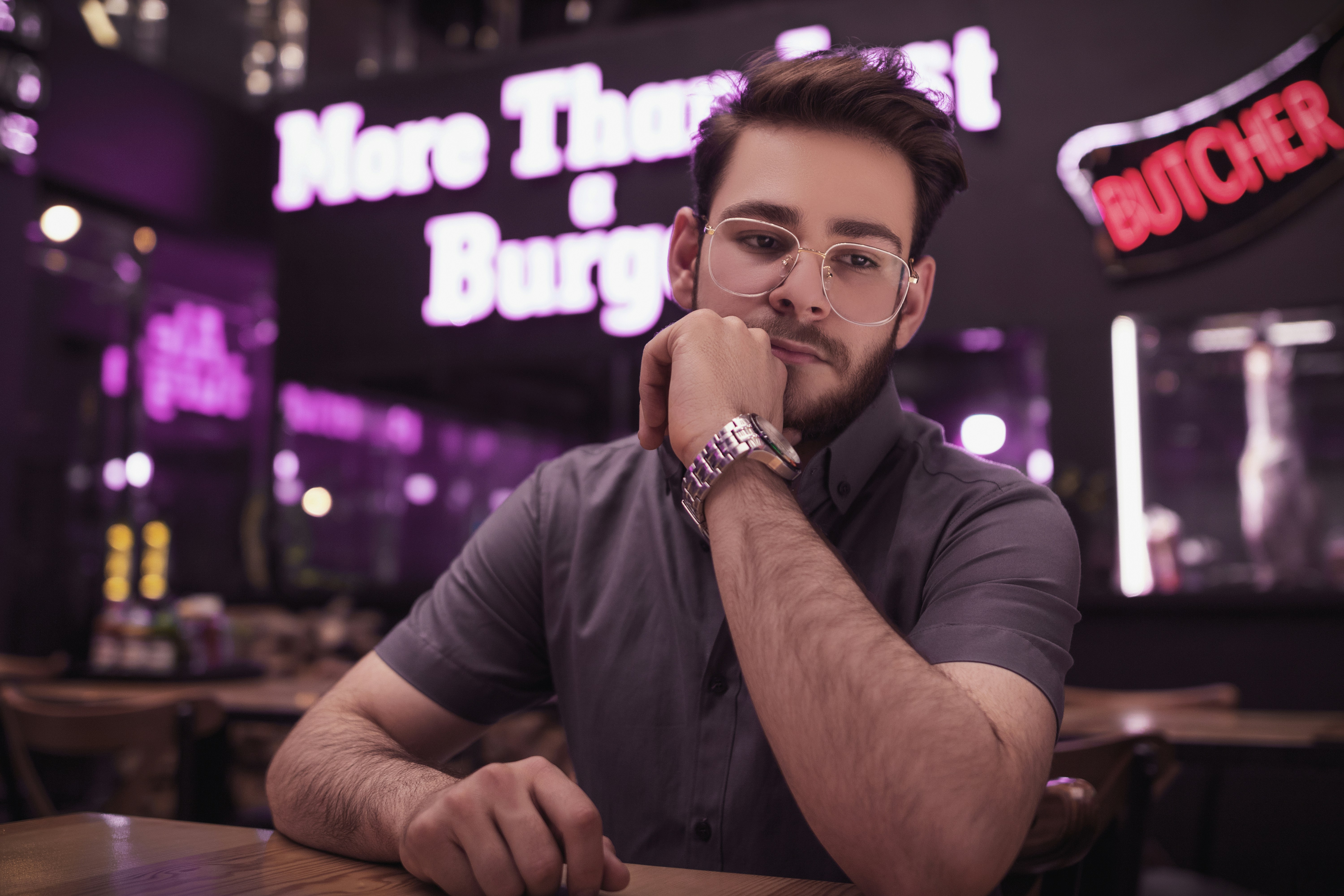 a man sitting at a table with his hand on his chin