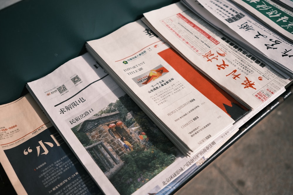 a pile of newspapers sitting on top of a table