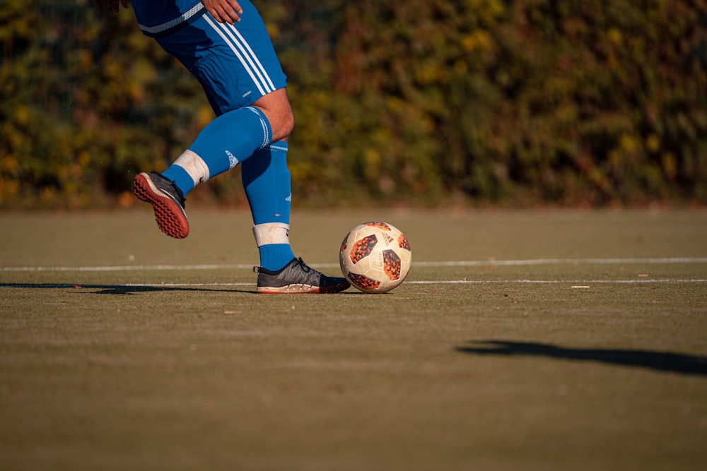 a person kicking a soccer ball on a field