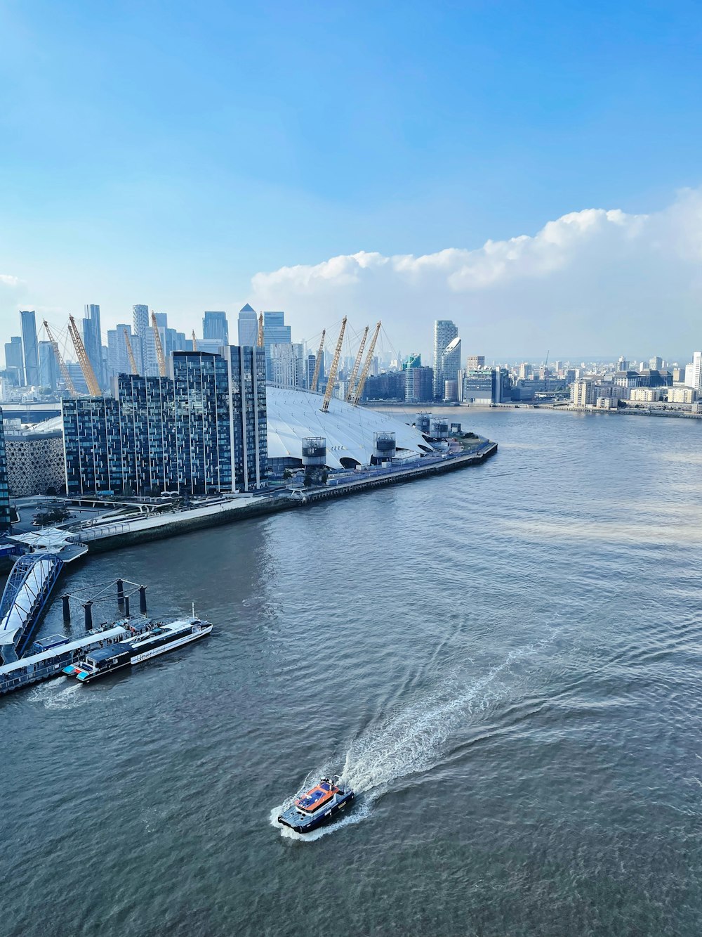 a boat traveling down a river next to a large city