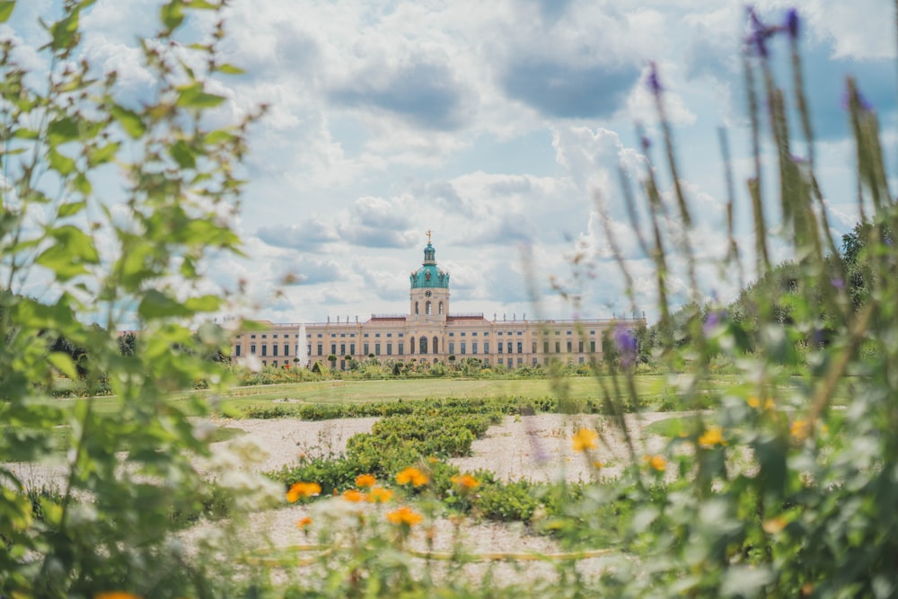 a large building with a clock tower in the middle of a field