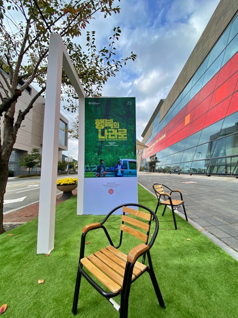 Close-up of hands setting up an eye-catching outdoor ad display with a green leafy backdrop