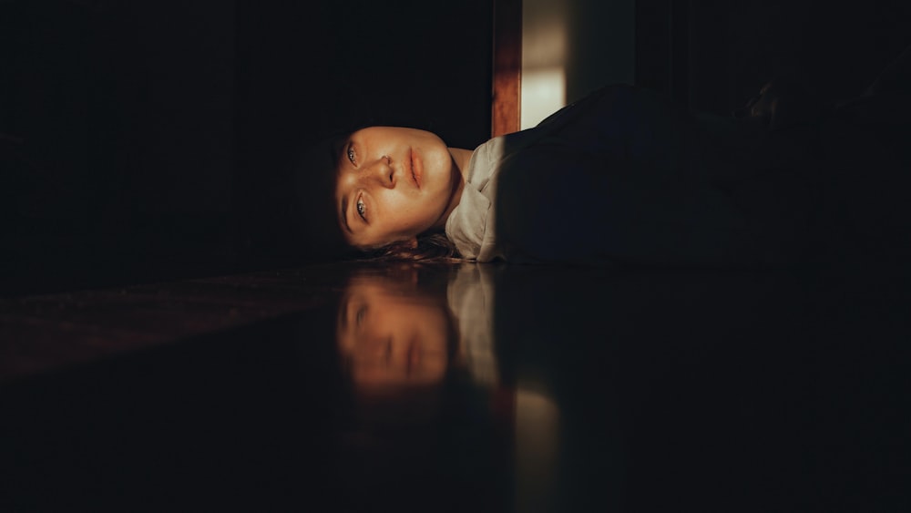 a man laying on the floor in the dark