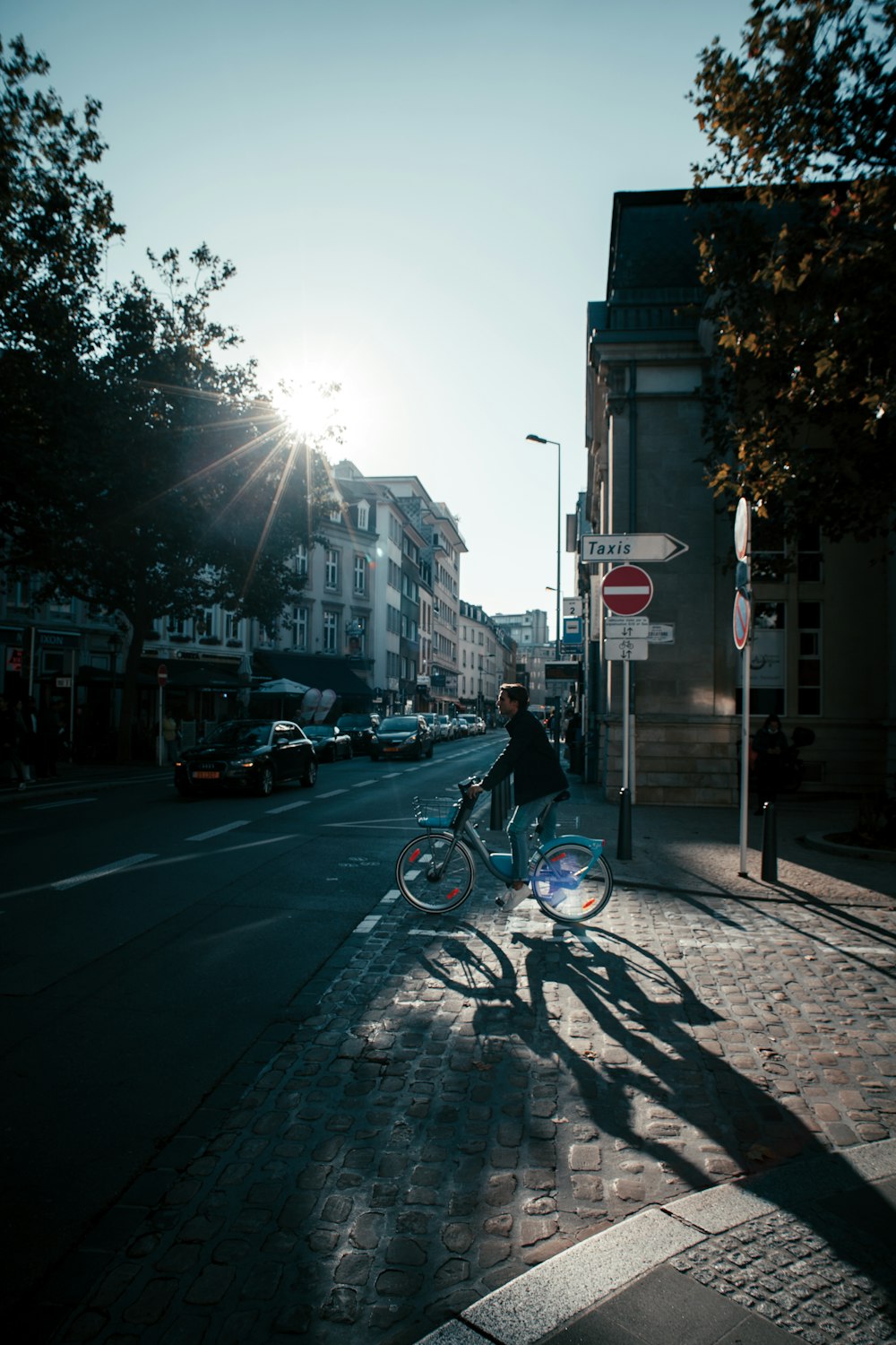 a man riding a bike down a street next to tall buildings