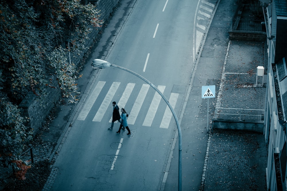 a couple of people walking across a street