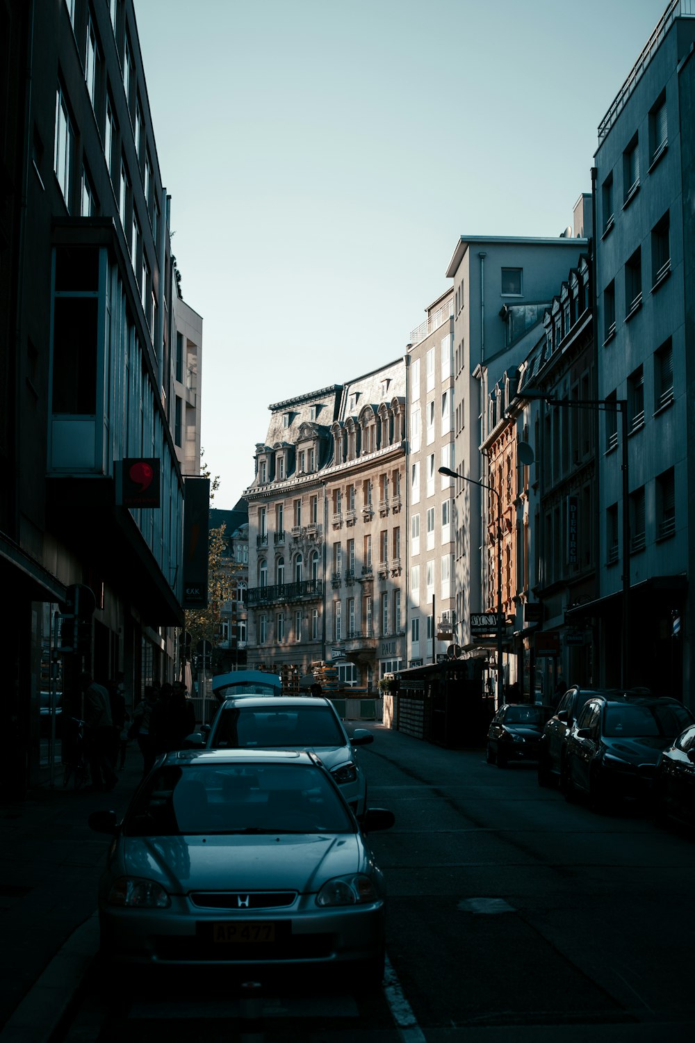 a car parked on the side of a street next to tall buildings