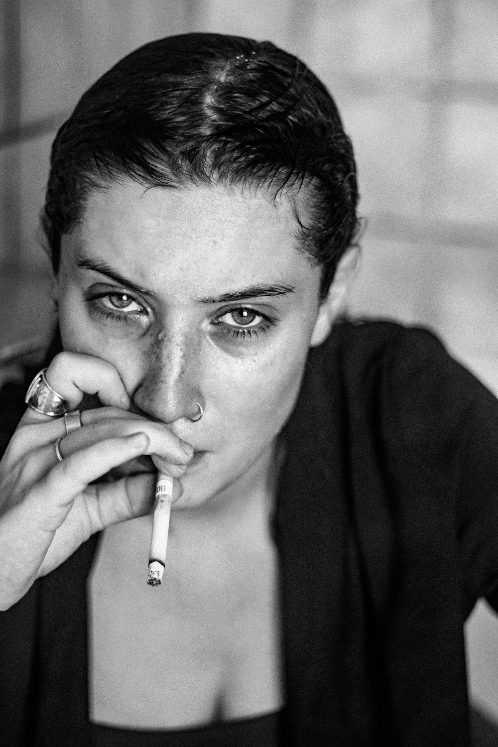 a black and white photo of a woman smoking a cigarette