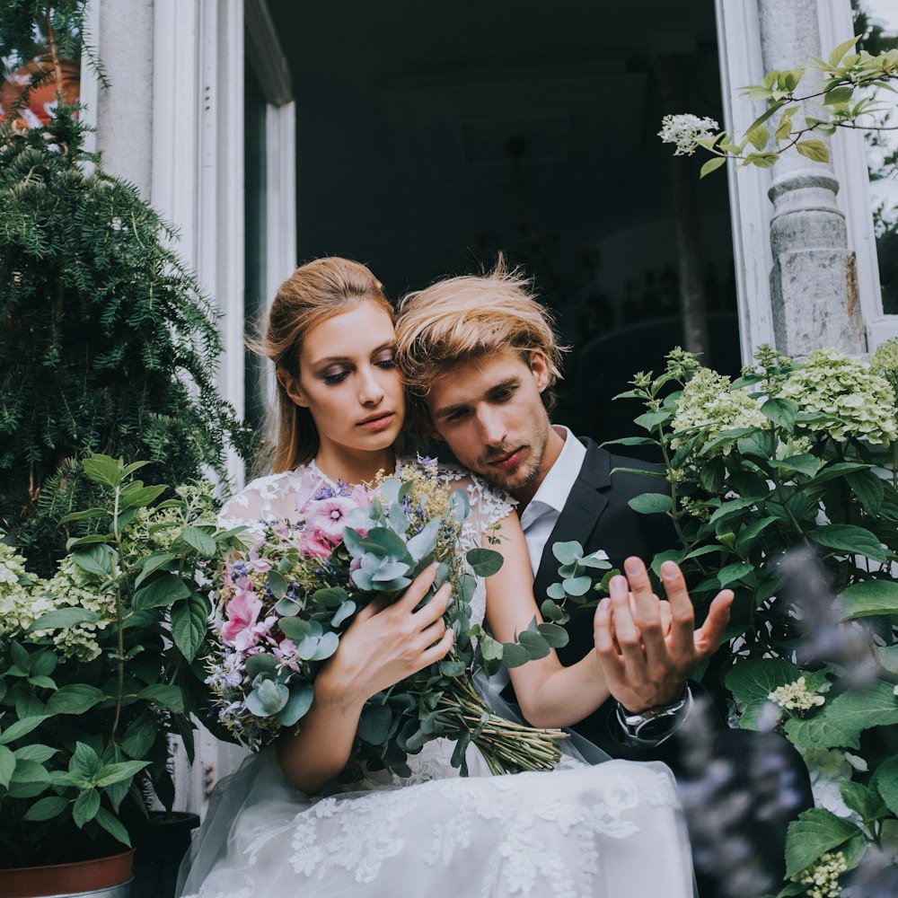 a man and a woman holding a bouquet of flowers