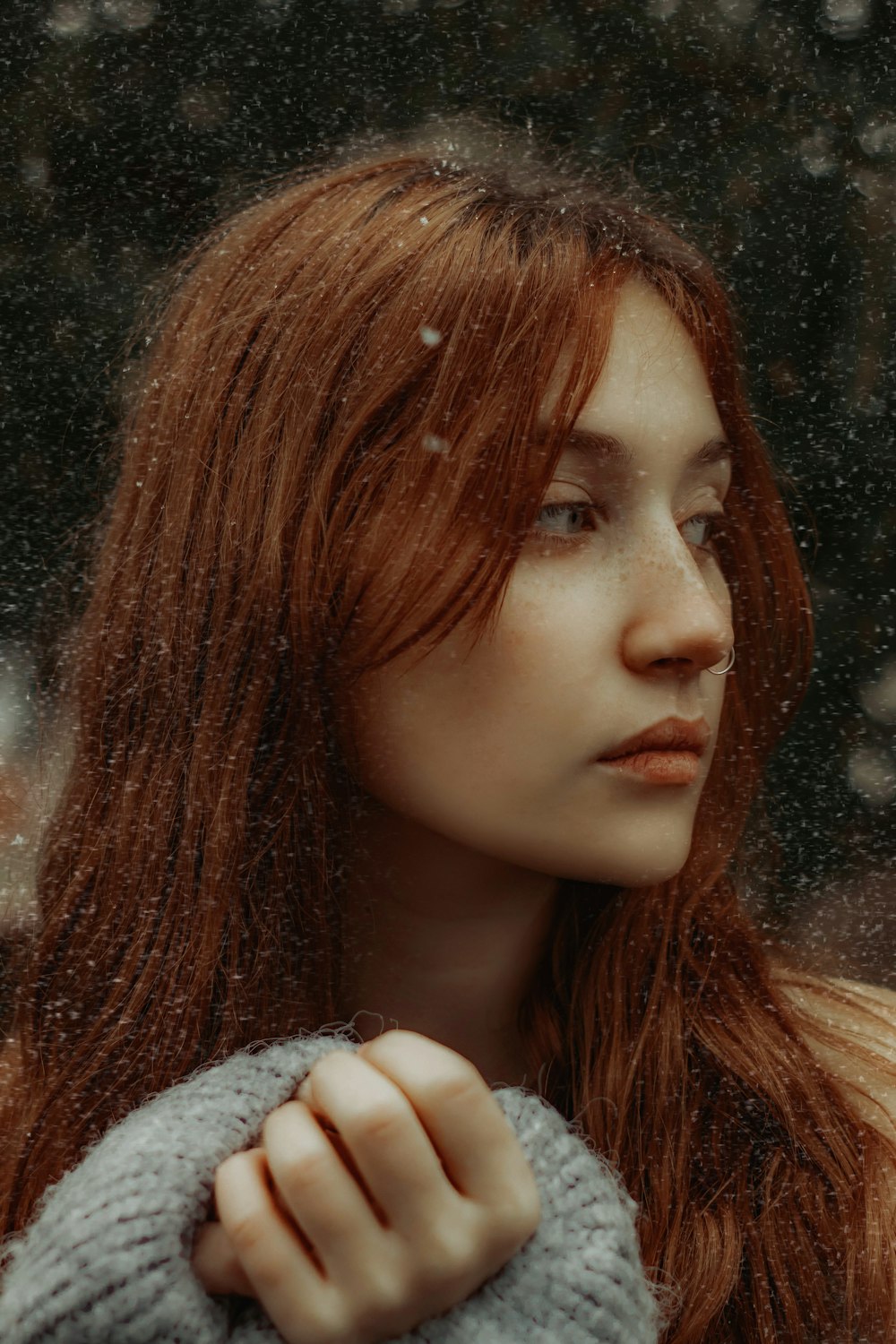 a woman with long red hair is standing in the snow