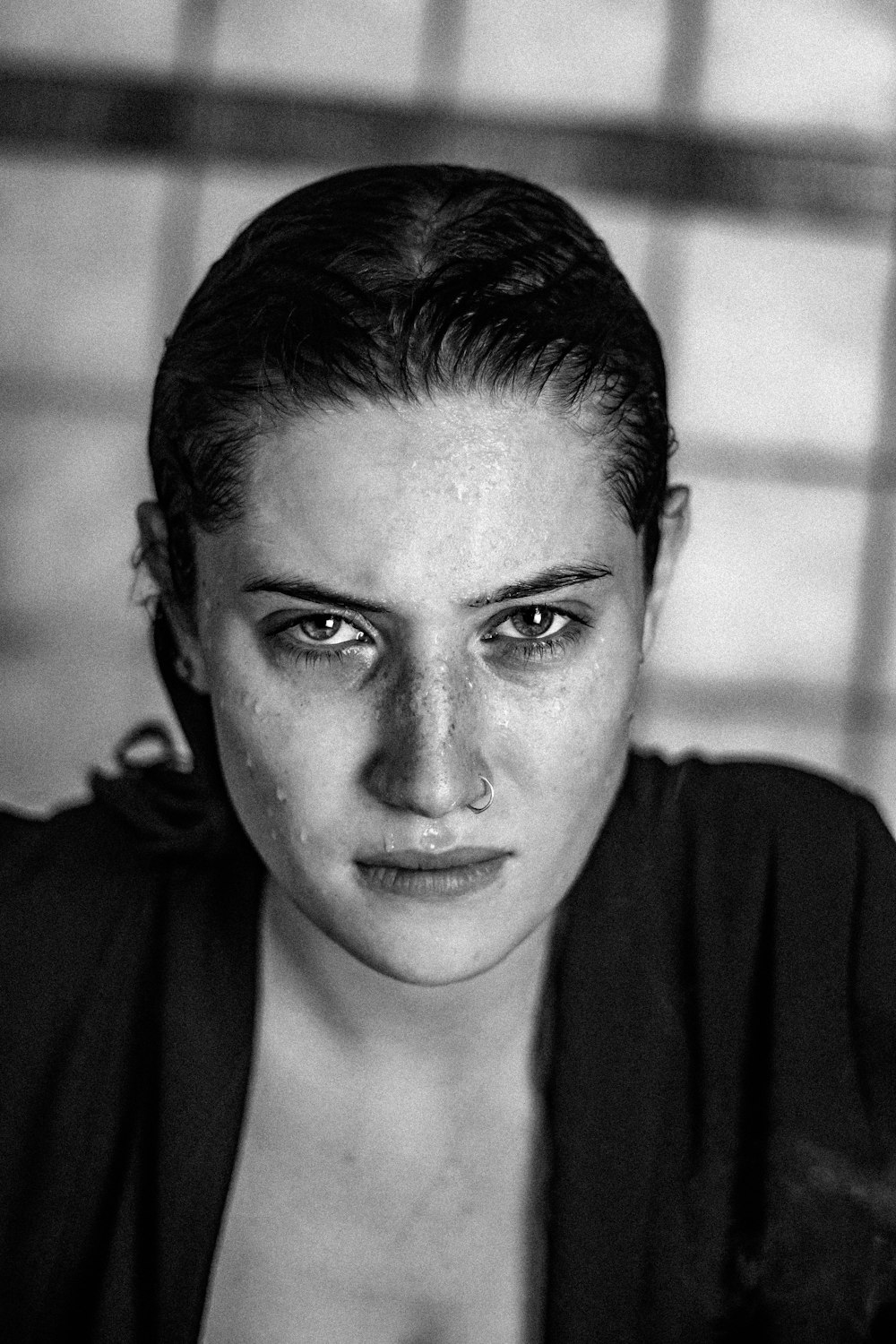 a black and white photo of a woman with freckles on her face