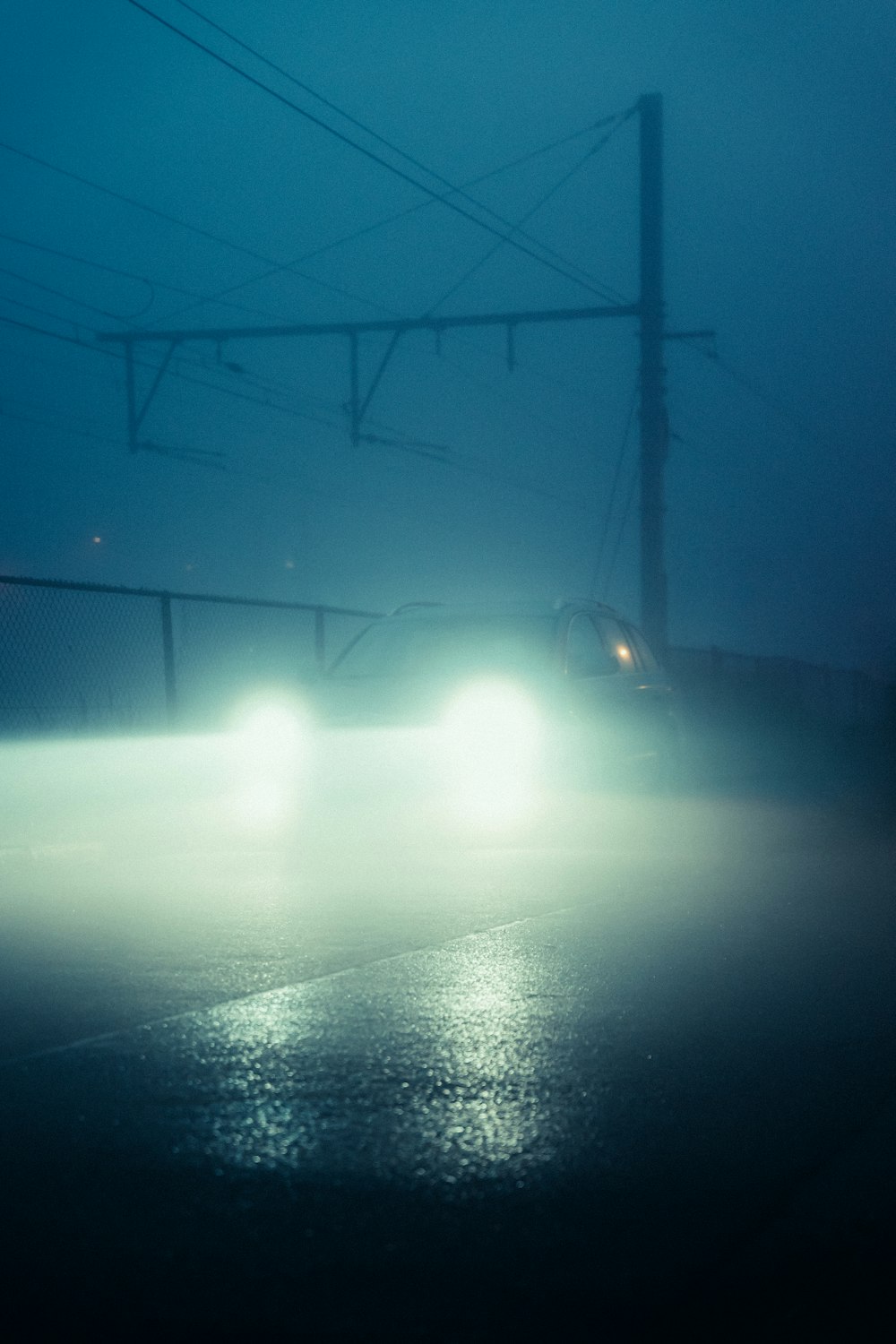 a car driving down a foggy road at night