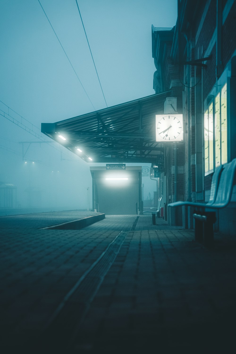 a train station with a clock on a foggy day