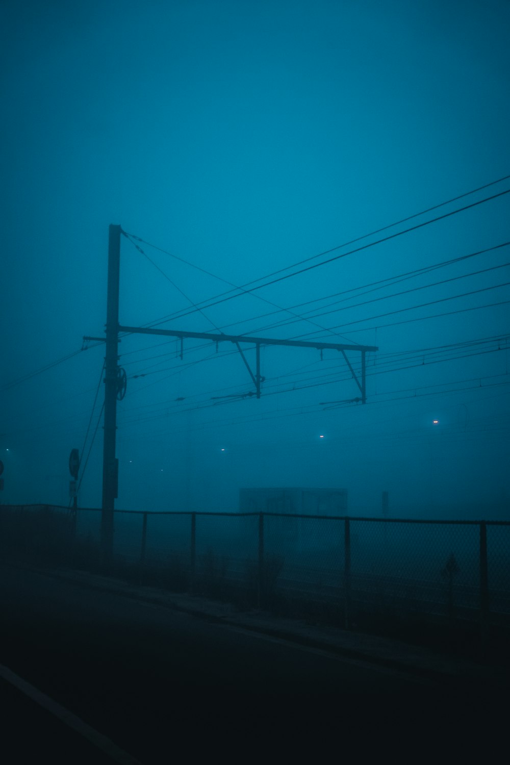 a foggy street with power lines in the distance