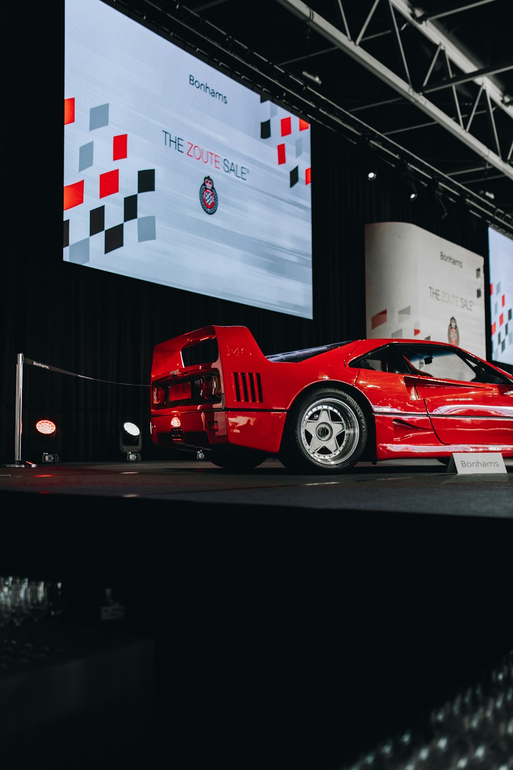 a red sports car on display at a car show