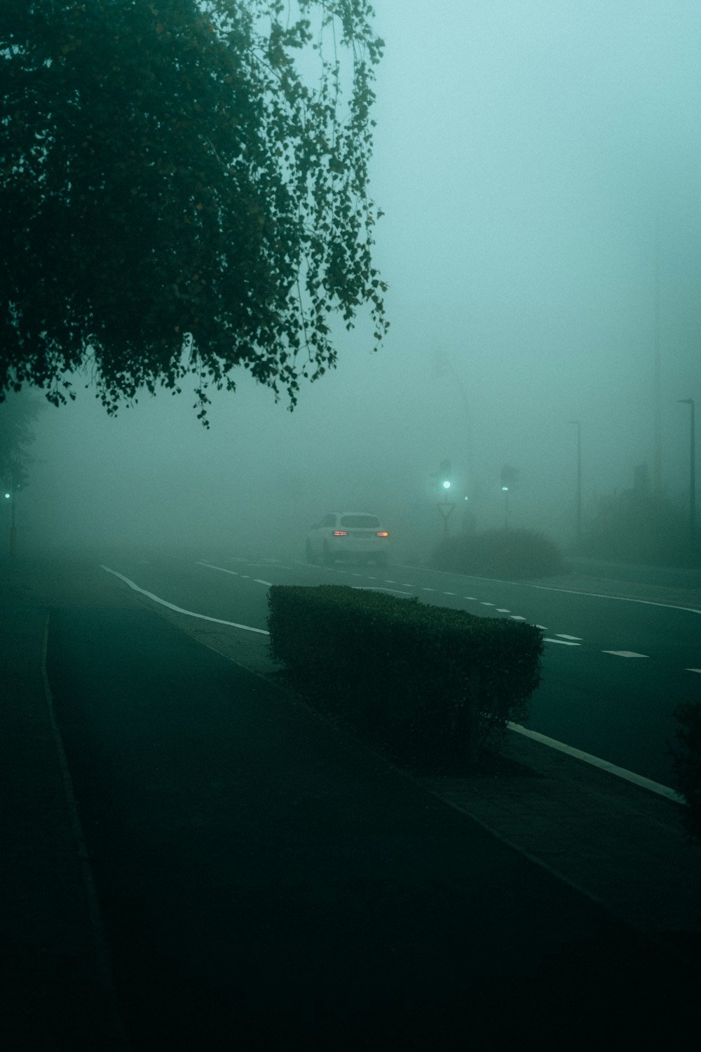 um carro dirigindo por uma estrada no nevoeiro