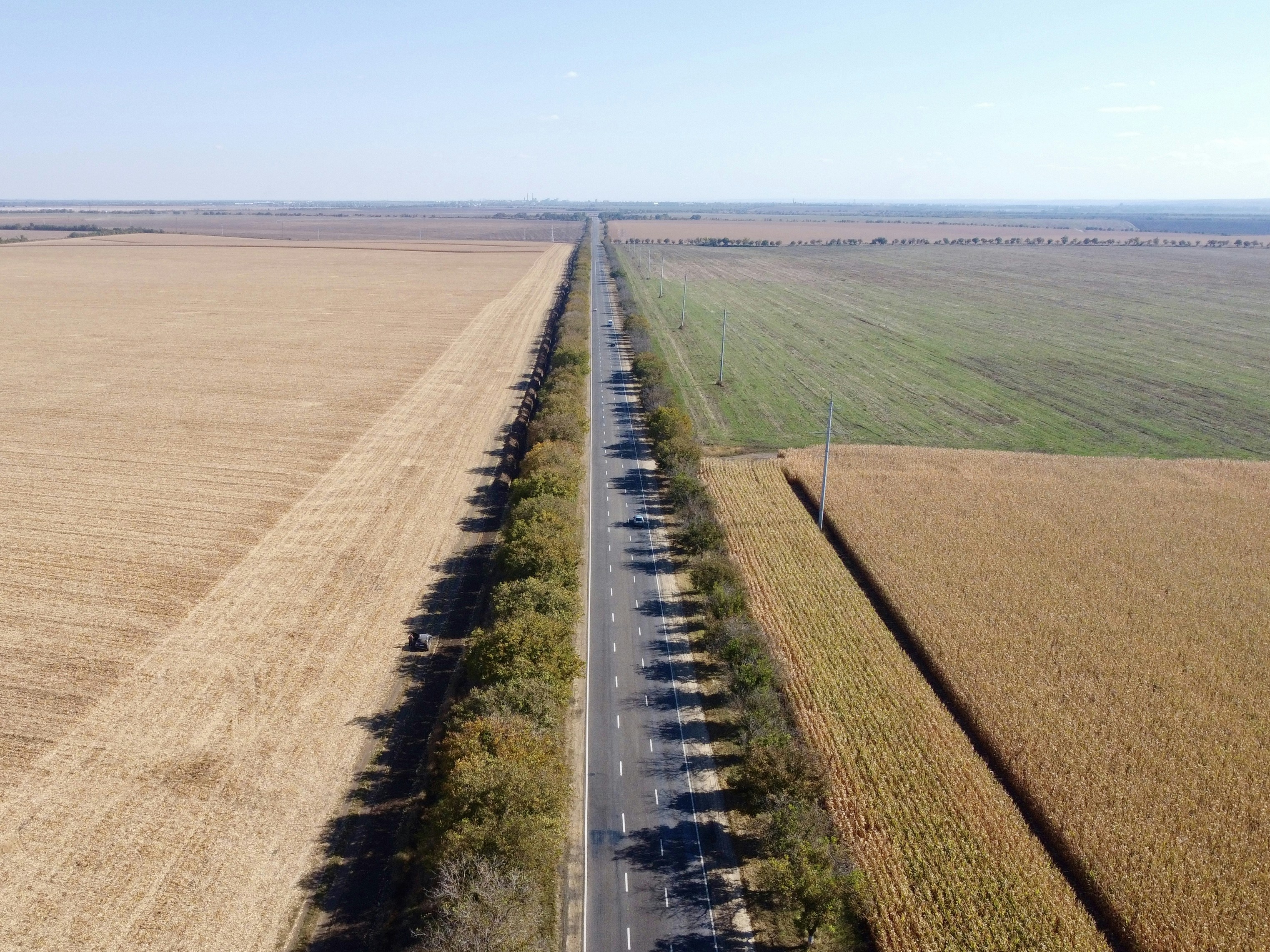 an aerial view of a road in the middle of a field