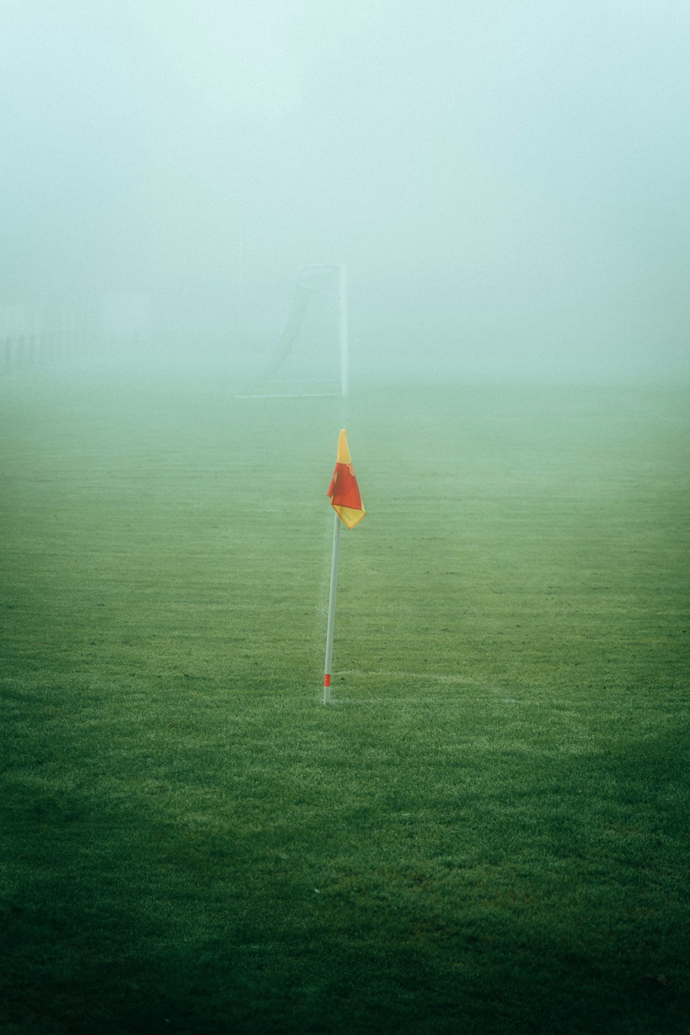 a red and yellow traffic sign in the middle of a foggy field