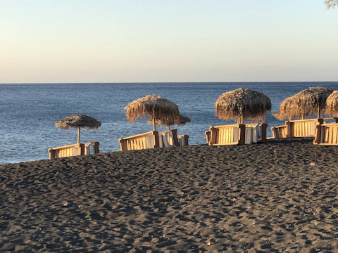 A serene beach setting with a small group relaxing under umbrellas during a private retreat.