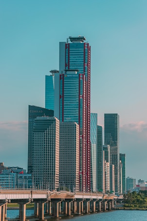 a city skyline with tall buildings and a bridge