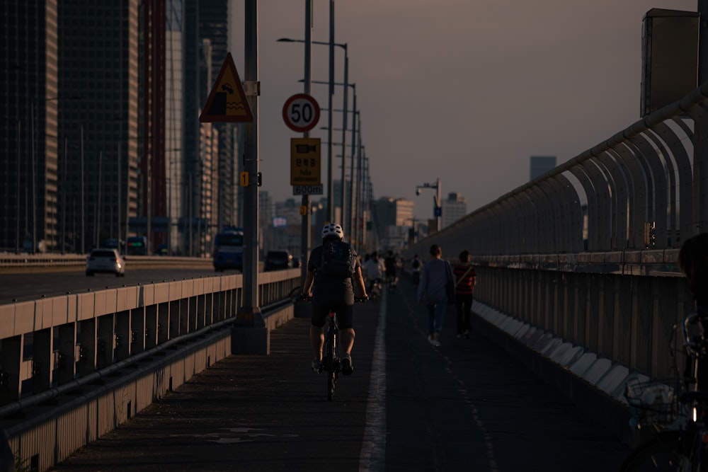 a group of people riding bikes down a bridge