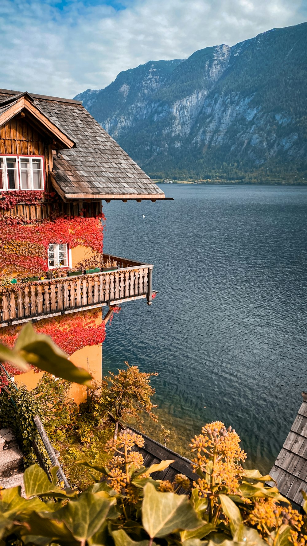 a house with a balcony next to a body of water