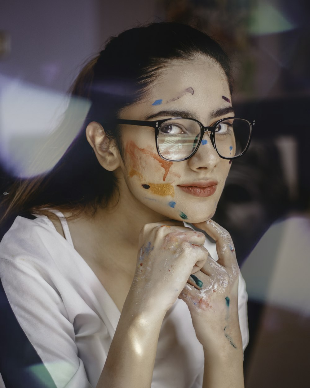 a woman wearing glasses with paint all over her face