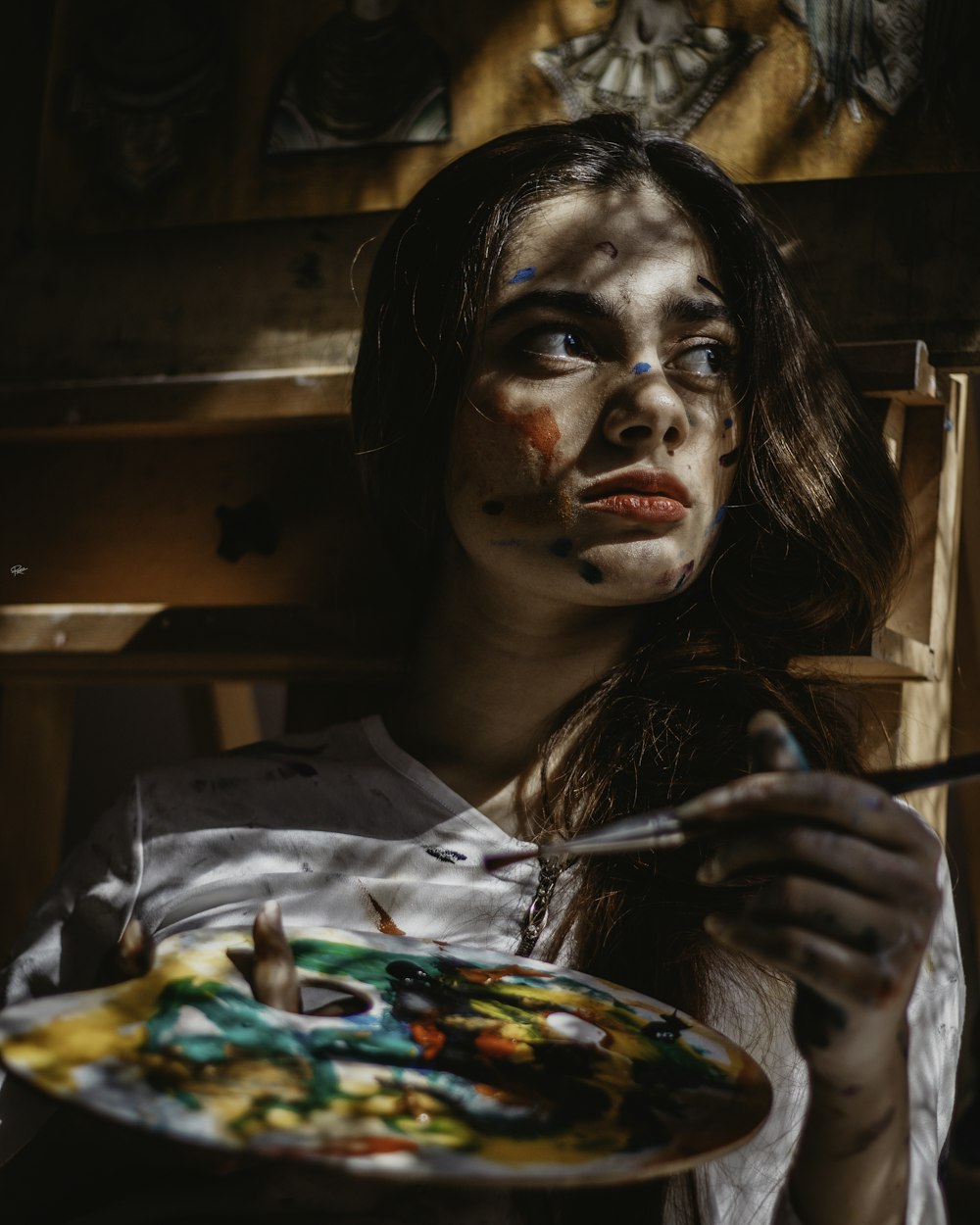 a woman holding a plate with paint on her face