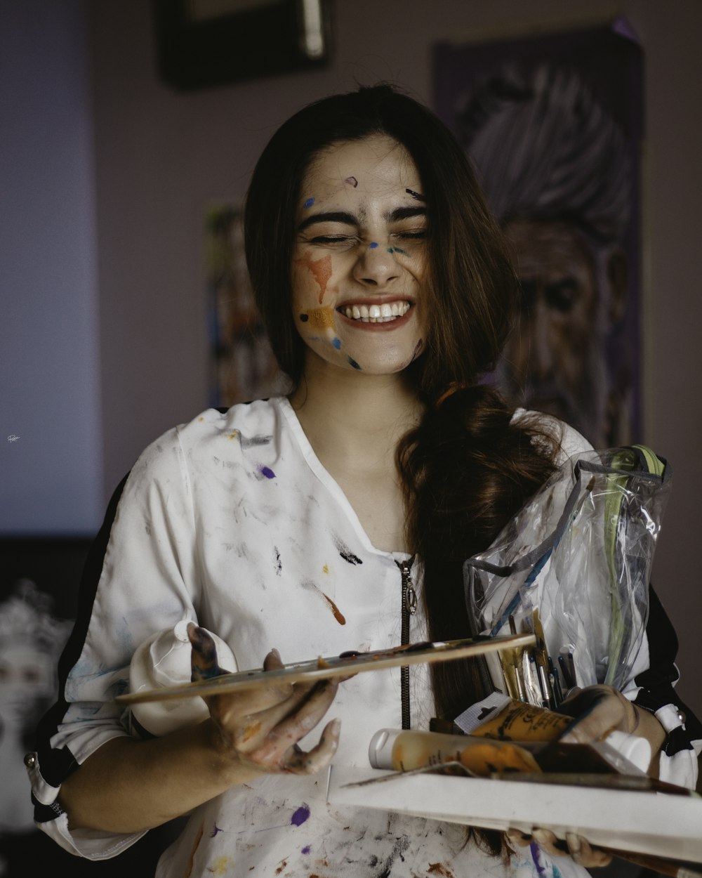 a woman with face paint holding a paintbrush and palette