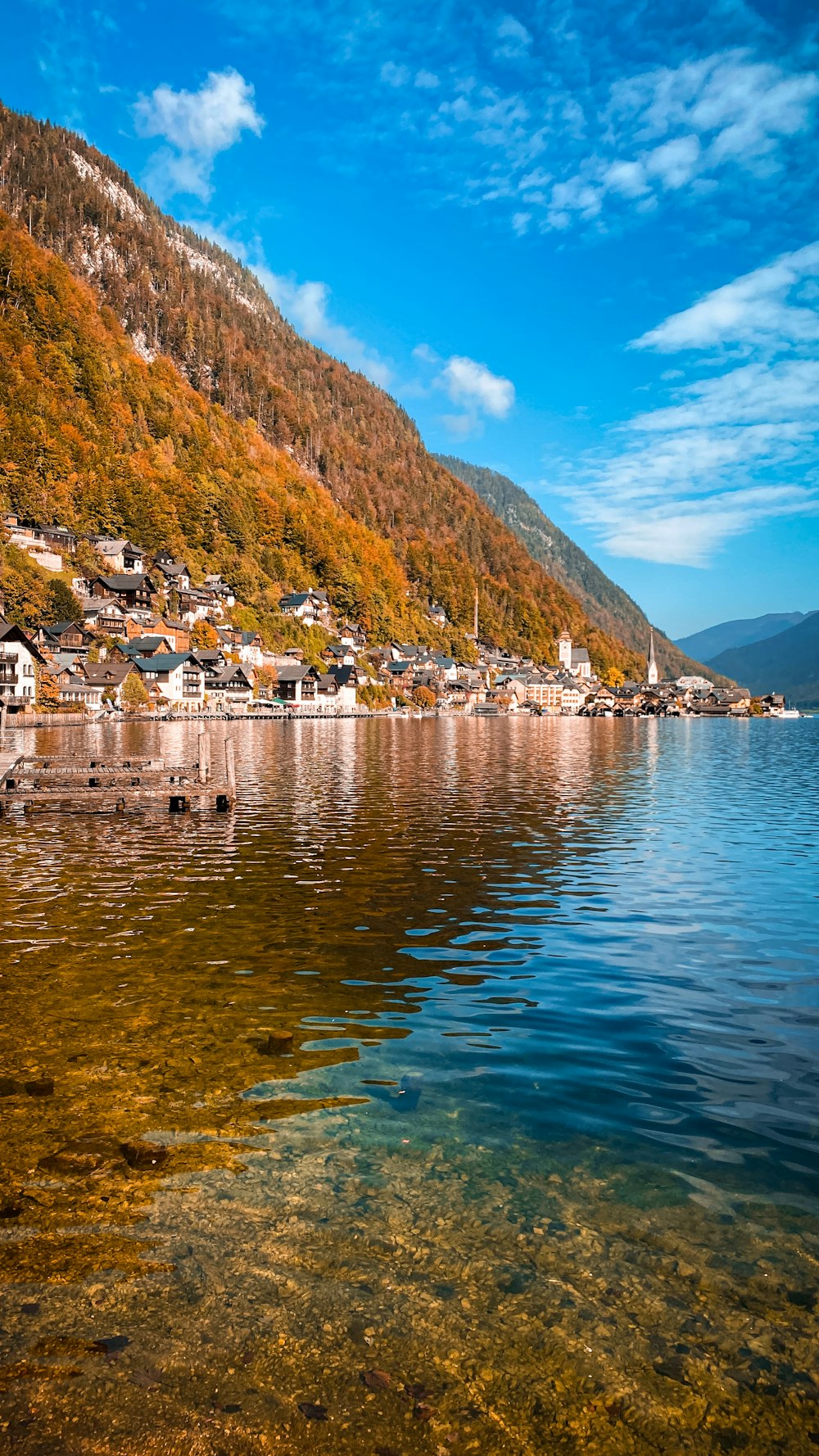 a body of water with houses on a hill in the background