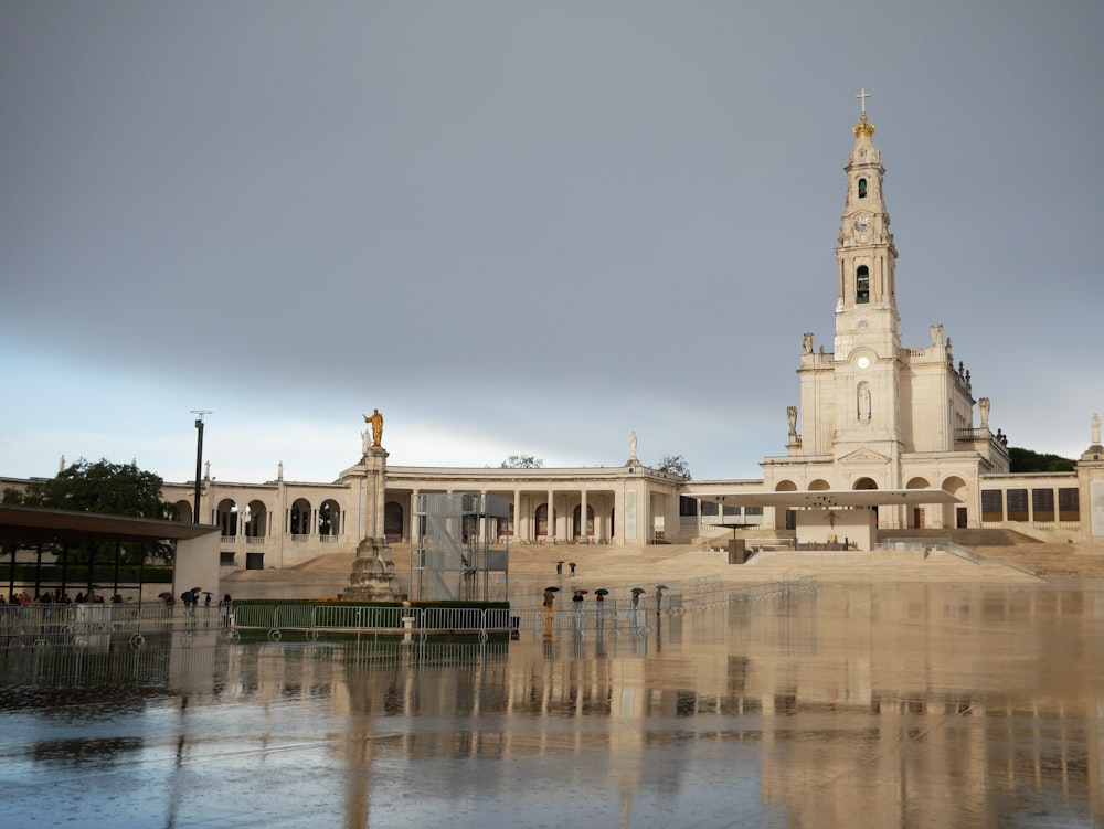 a large building with a clock tower next to a body of water